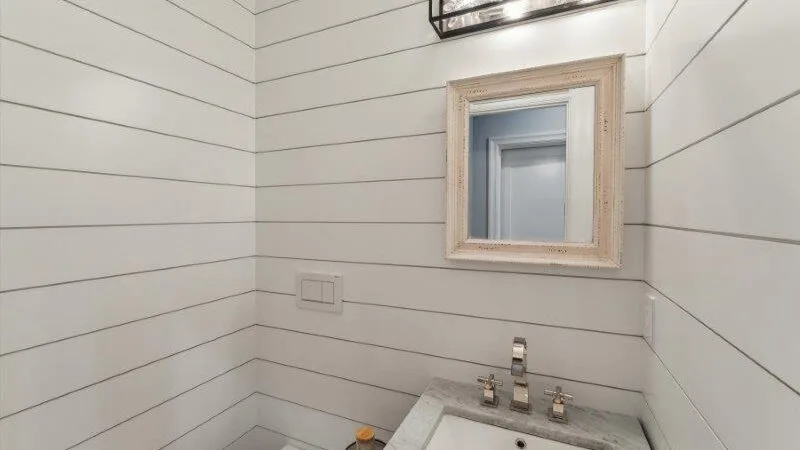 A small bathroom with a wall-mounted mirror above the sink.