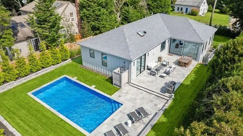 Aerial view of a modern house with a swimming pool and patio.