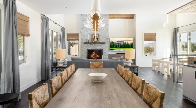 Comedor con una mesa larga y una chimenea al fondo.