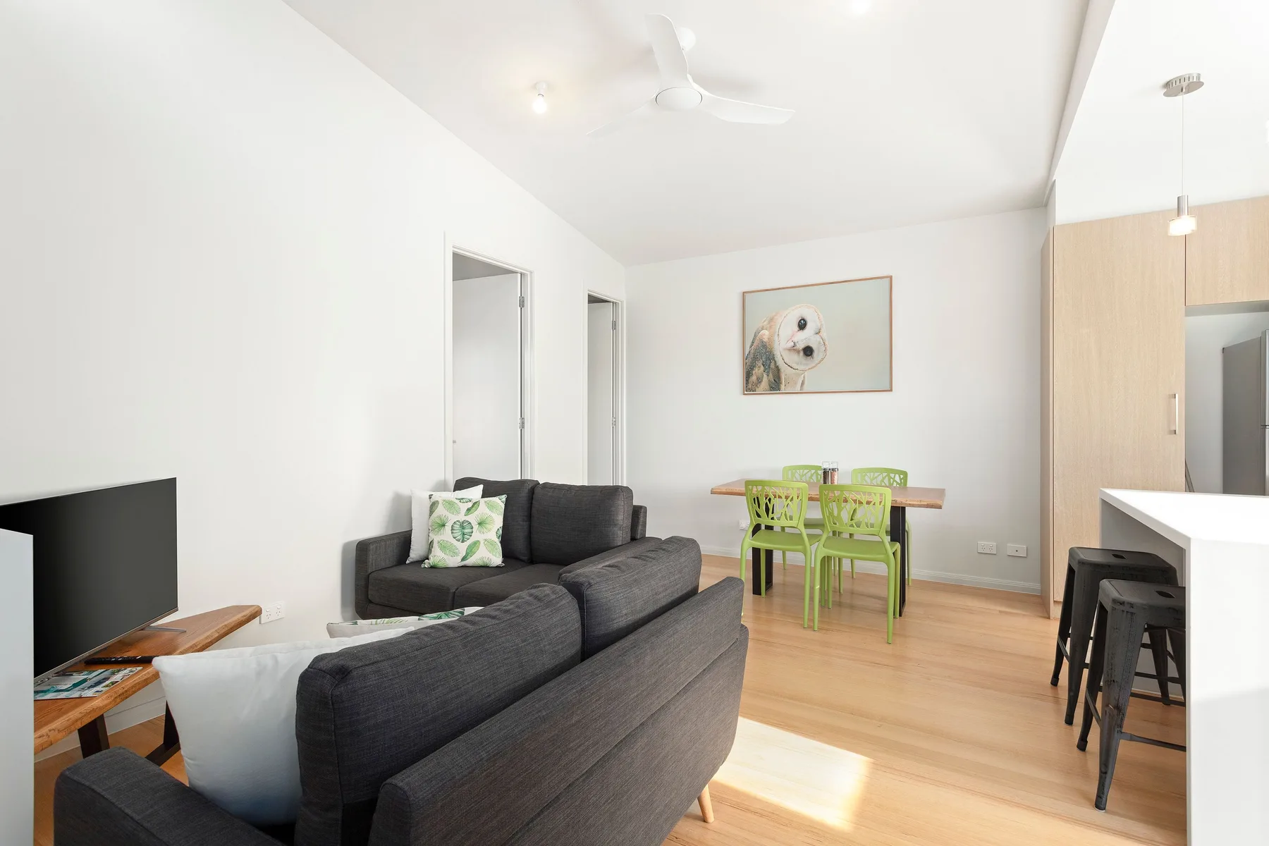 Bright living and dining area with dark seating and a green dining set.