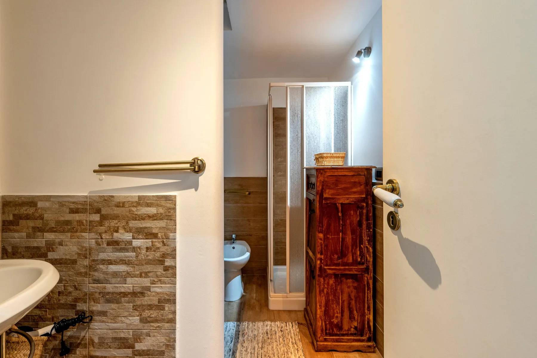Un baño con lavabo, inodoro y armario de madera.