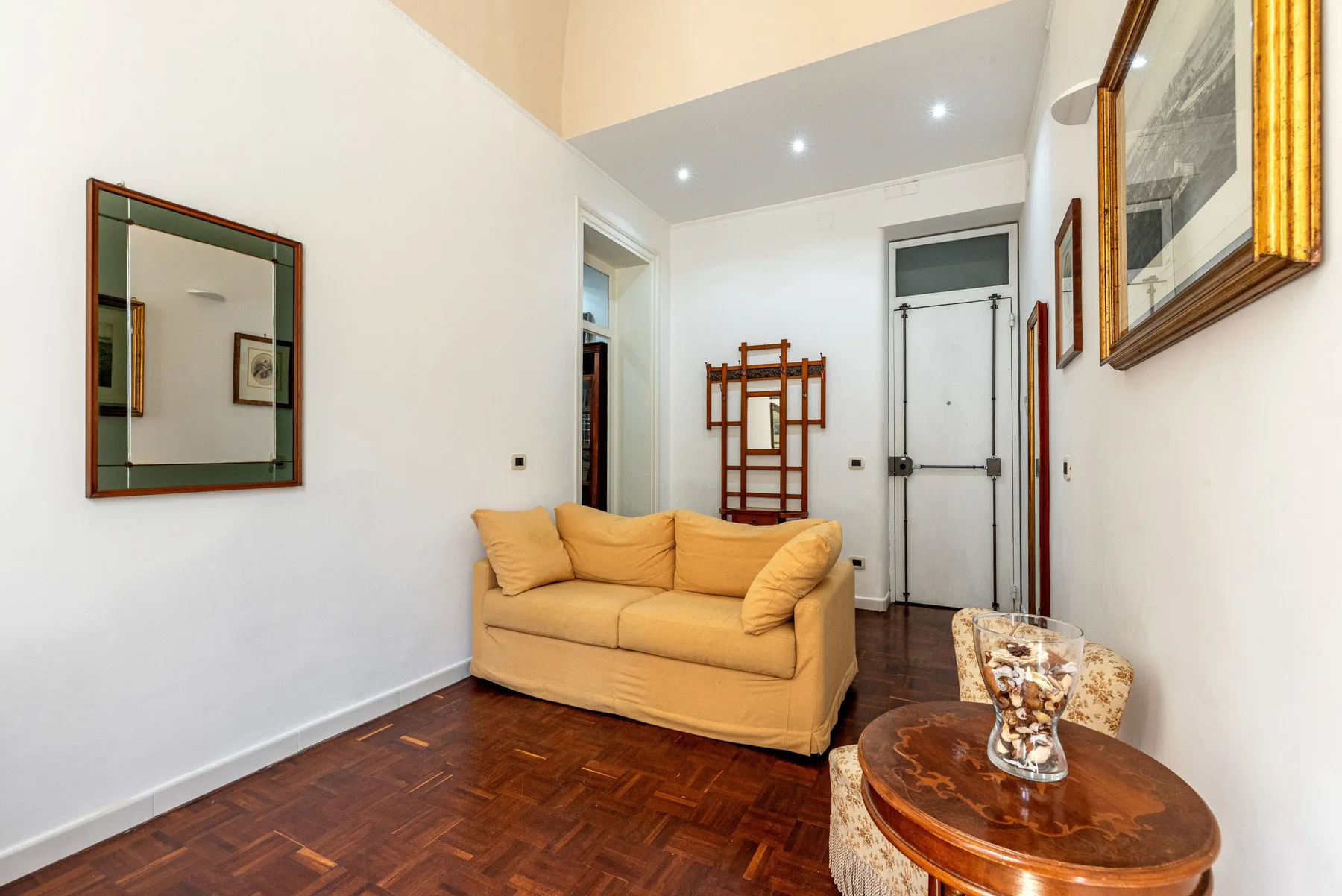 Una sala luminosa con un sofá amarillo y una mesa de centro de madera.