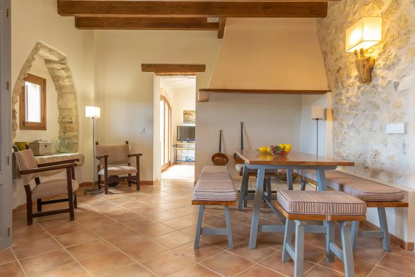 A rustic dining and sitting area with a wooden table and benches.