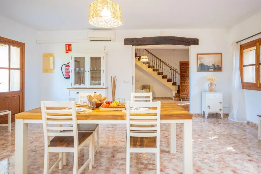 Un comedor luminoso con una mesa de madera y sillas blancas.
