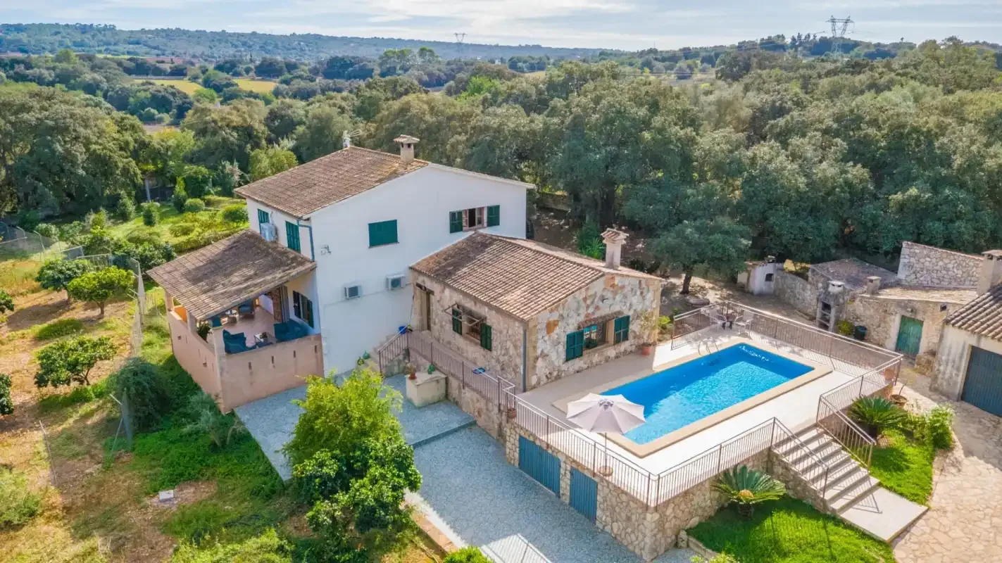 Una propiedad rural con piscina rodeada de árboles.