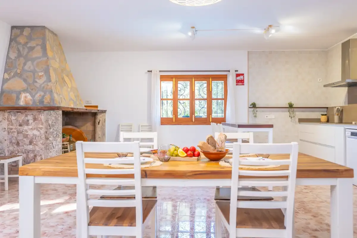 Comedor con una mesa de madera y una chimenea de piedra.