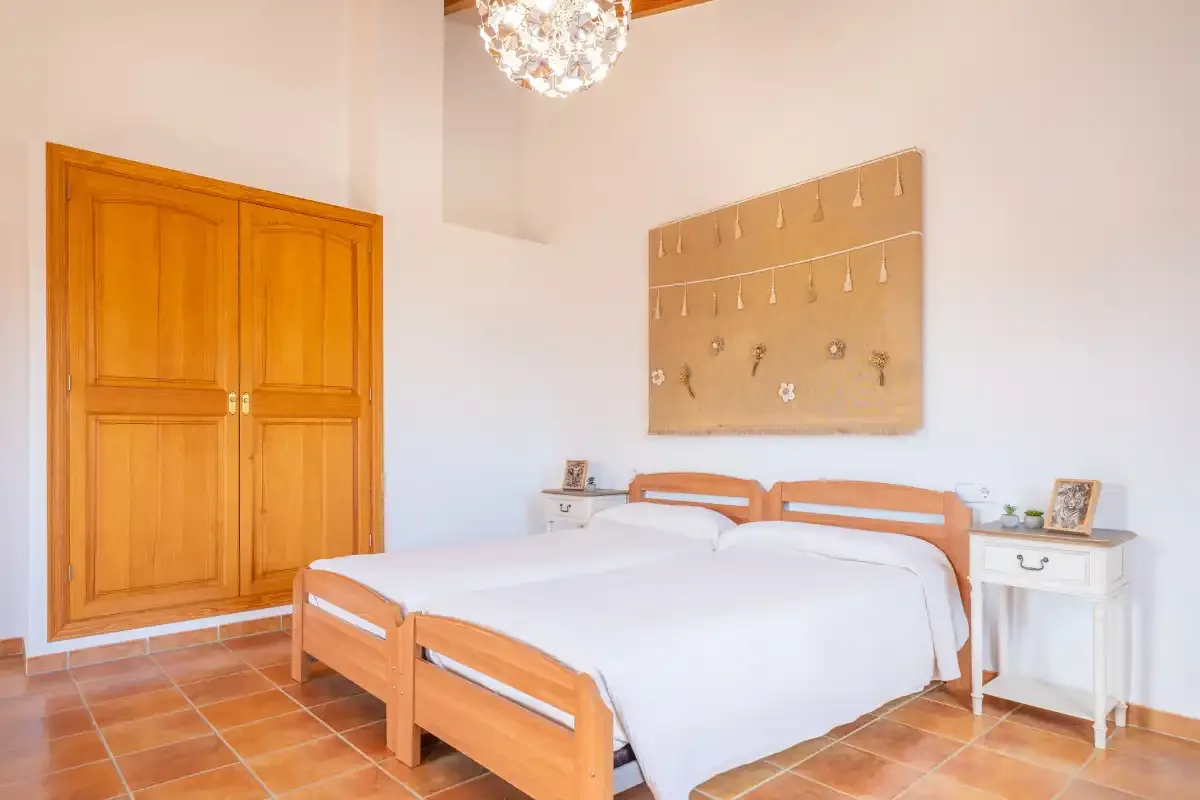 Un dormitorio con dos camas y un armario de madera.