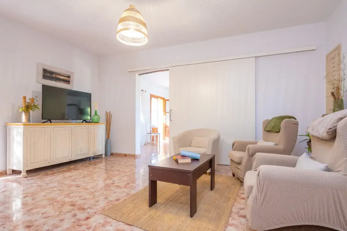 Una sala de estar con asientos alrededor de una mesa de centro y un televisor.