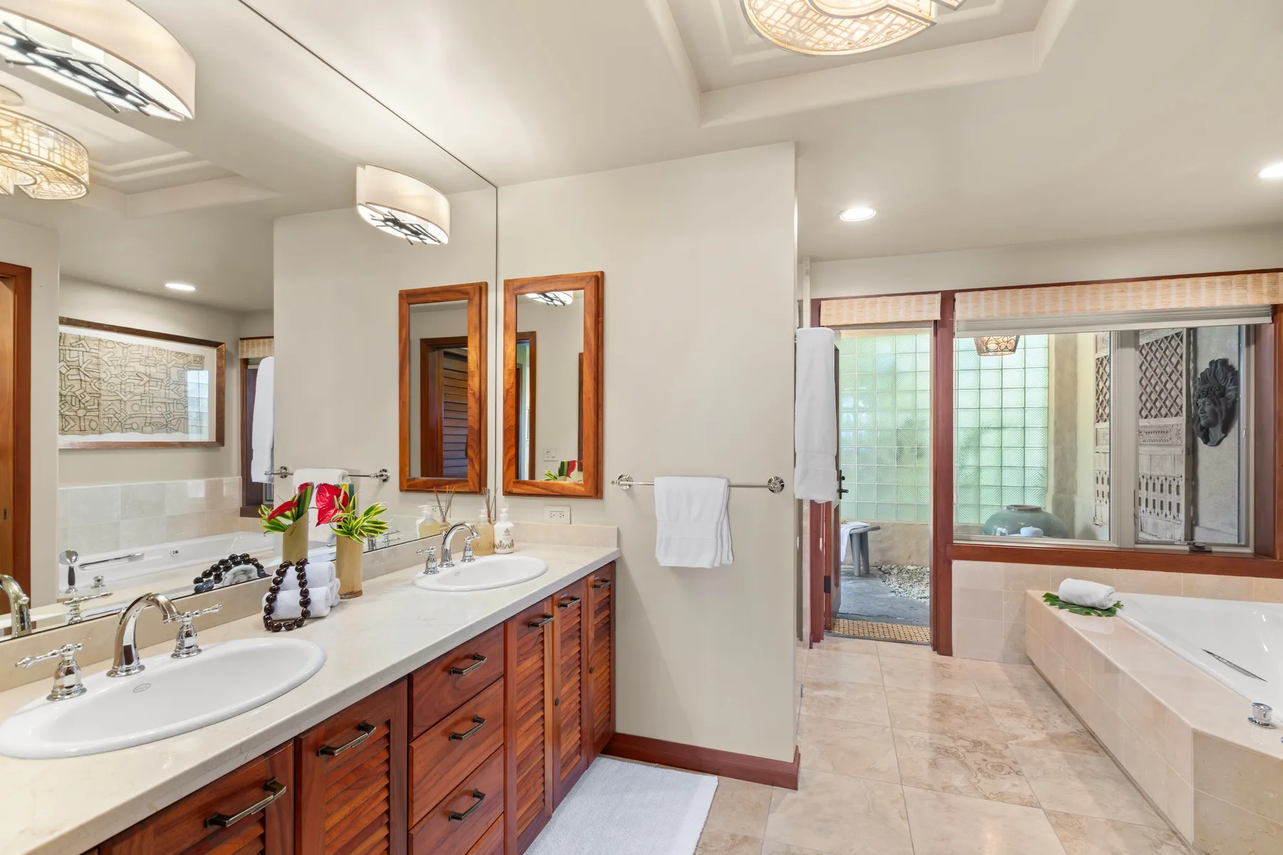Un baño luminoso con lavabo doble y una bañera junto a la ventana.