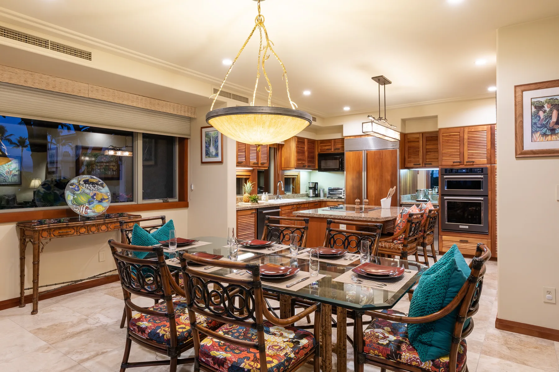 Un comedor con una mesa larga y sillas junto a una cocina abierta.