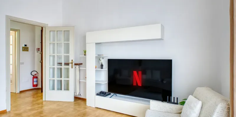A living room with a television on a white media unit.