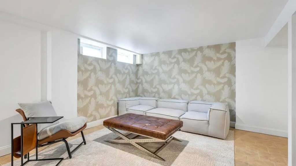 Una zona de estar con un sofá seccional, un sillón reclinable y una mesa de centro baja.