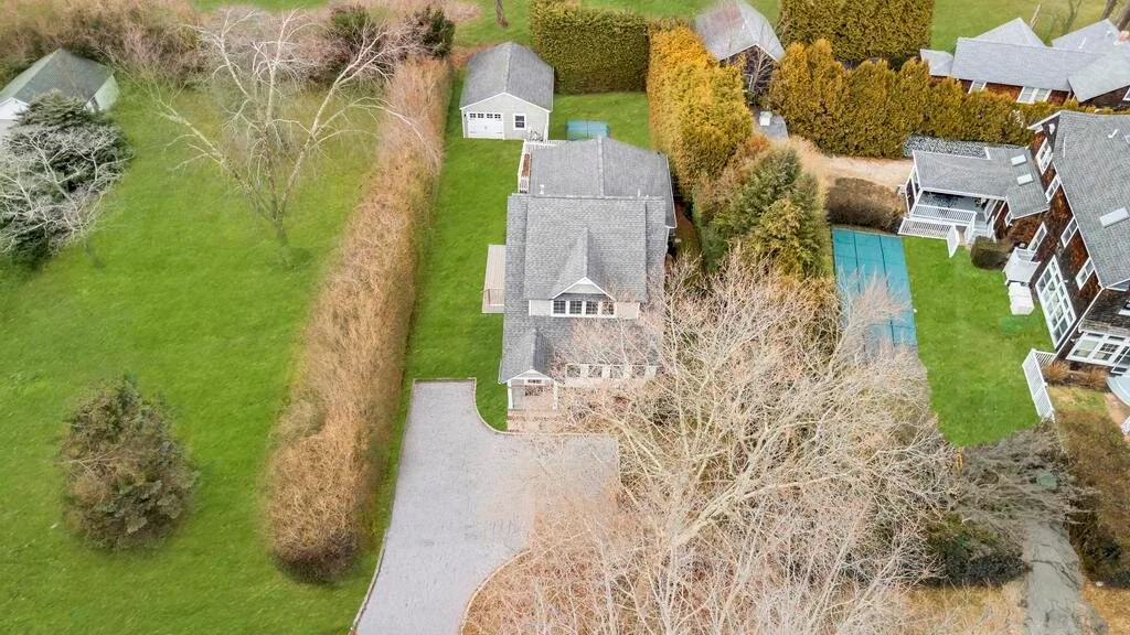 Vista aérea de una casa grande junto a una entrada y una piscina al aire libre.