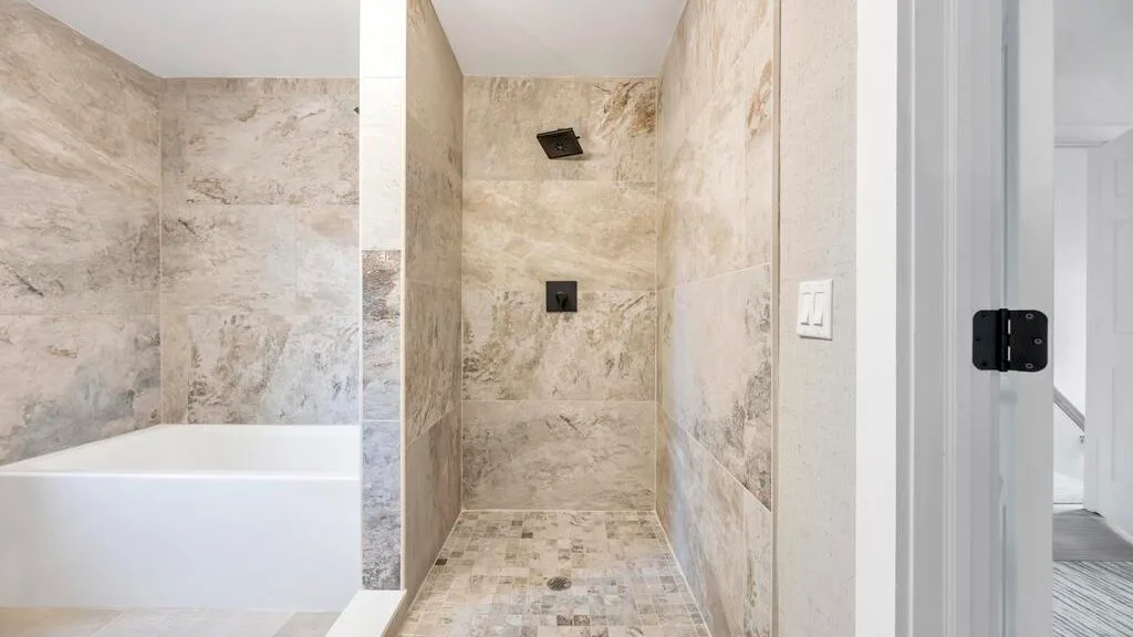 Un baño alicatado con una bañera junto a una ducha.