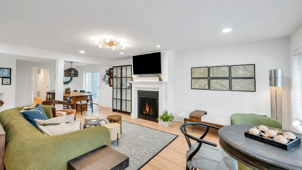 Una sala luminosa con asientos, una chimenea y un comedor.