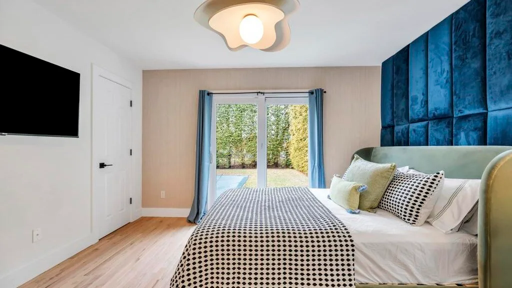 Un dormitorio con una cama junto a una ventana con cortinas azules.