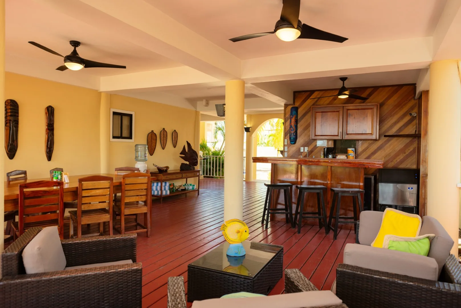 An open lounge and bar area with wooden flooring and seating.