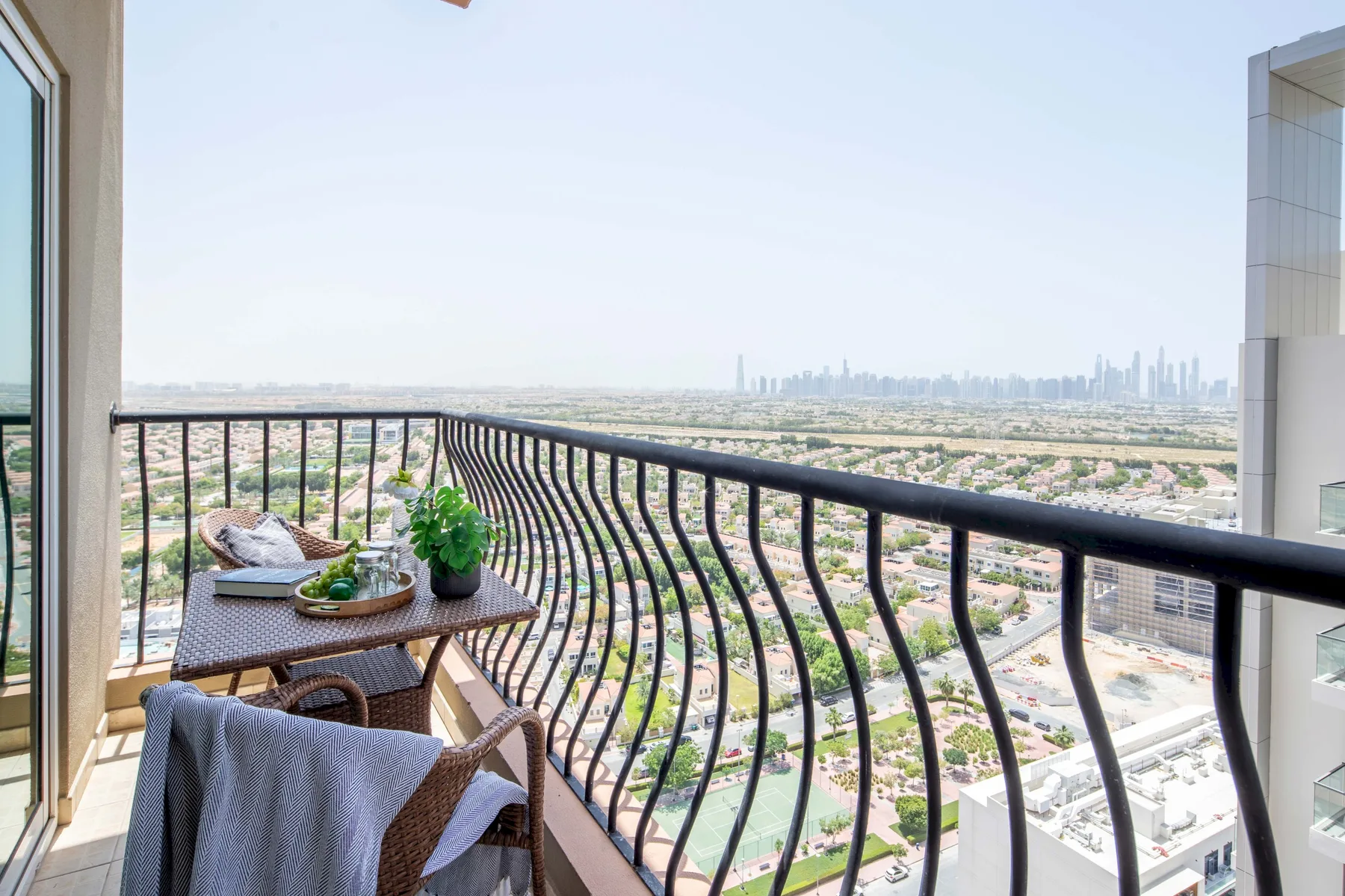 Una zona de estar en el balcón con una mesa pequeña ofrece vistas a la ciudad.