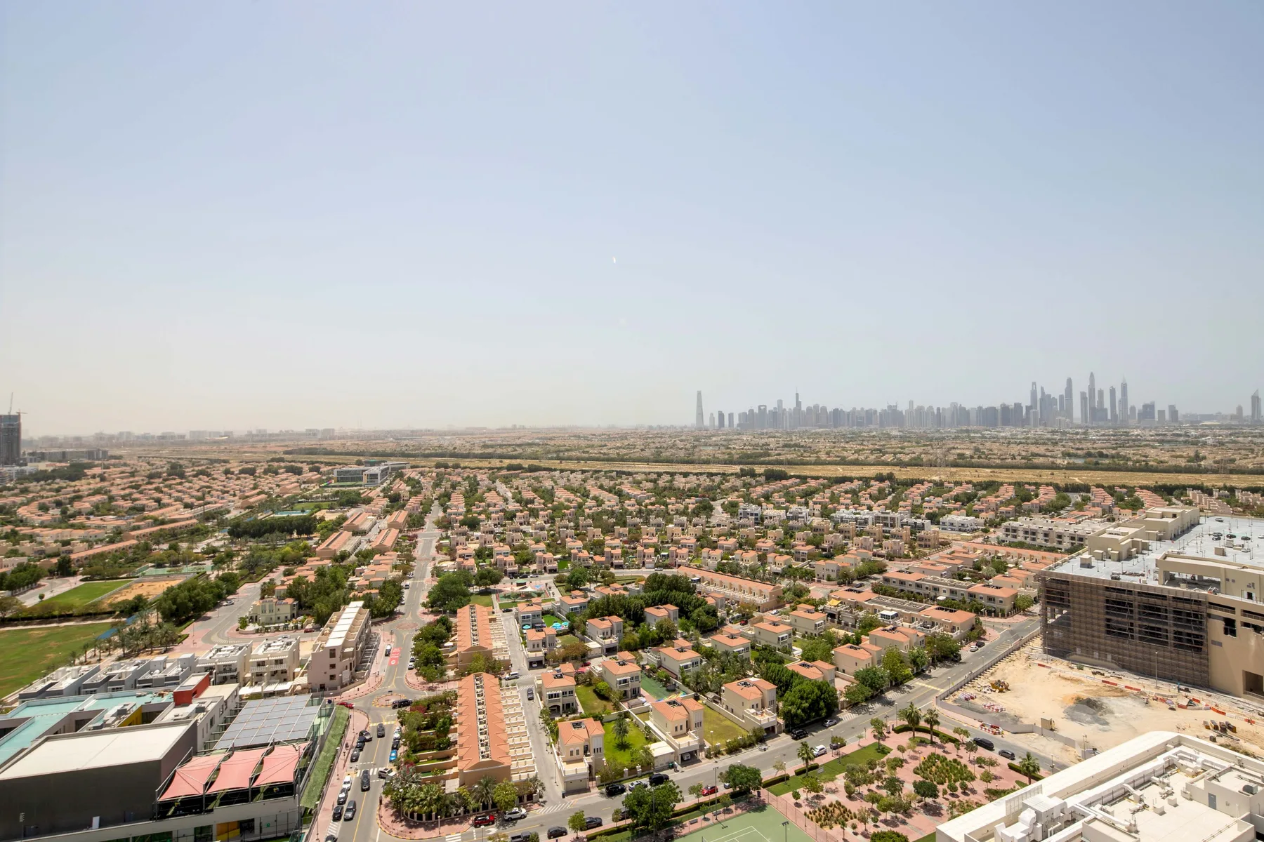 Una amplia vista urbana muestra un barrio residencial de baja altura y un horizonte lejano.
