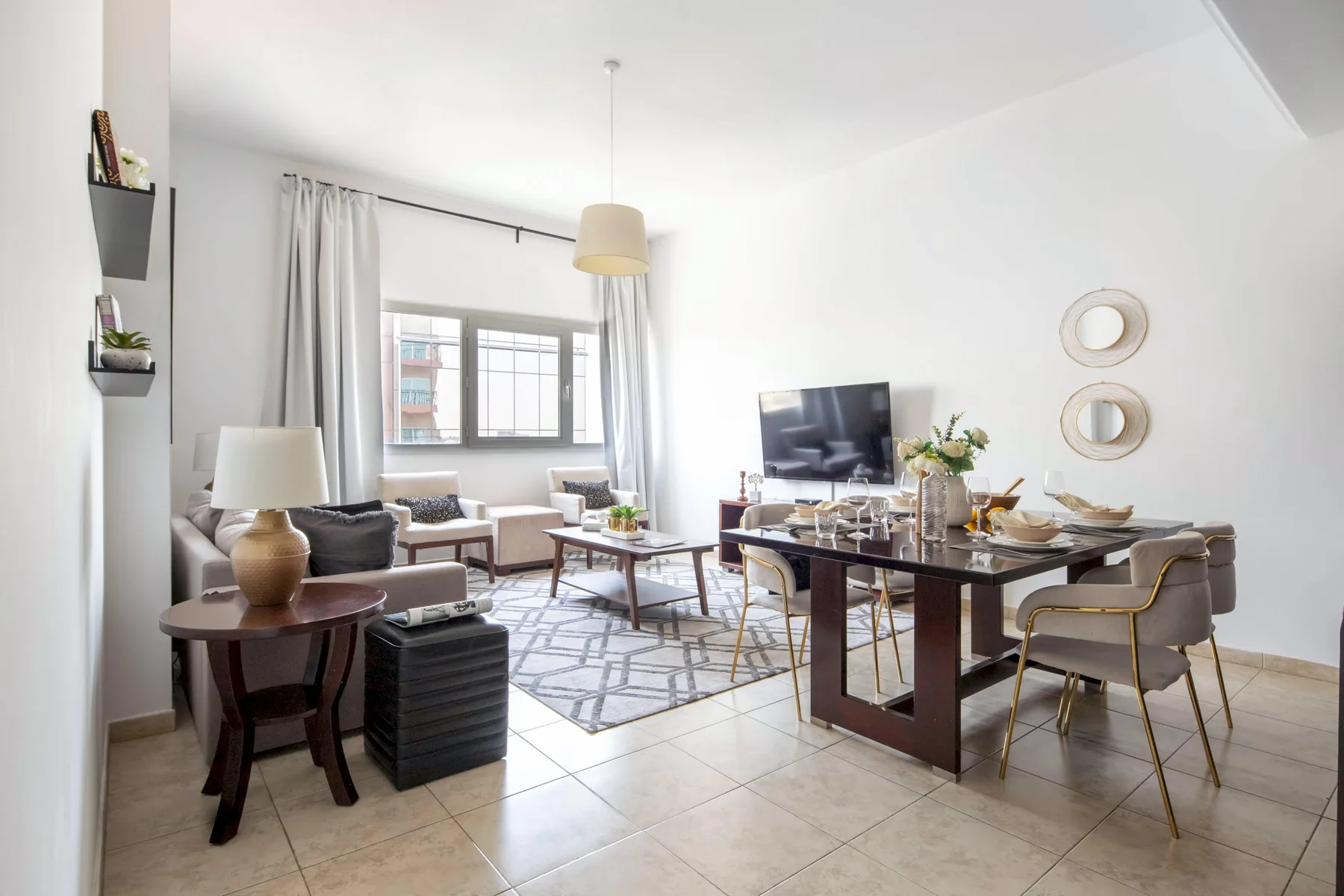Una luminosa sala de estar y comedor de concepto abierto, con una ventana grande y un televisor.