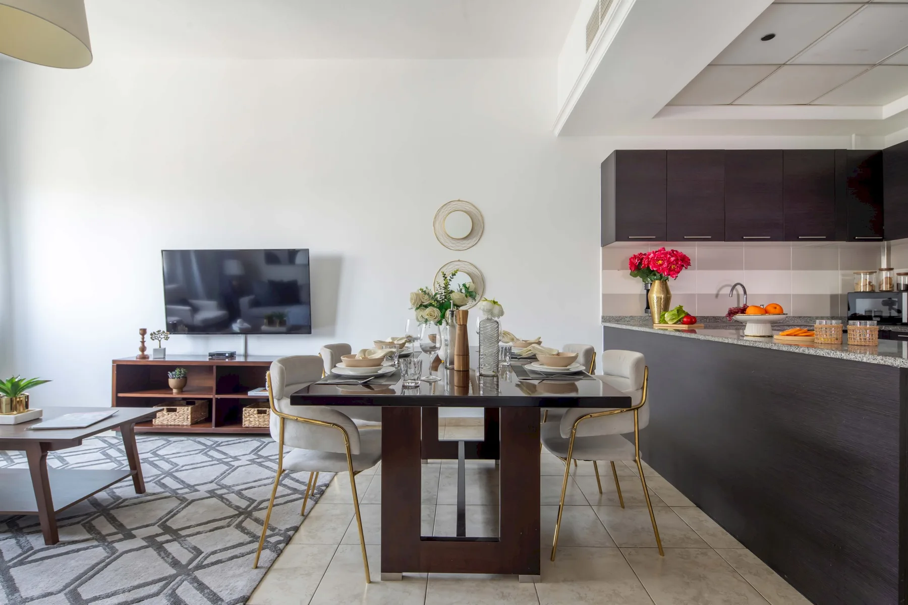 Comedor y cocina de concepto abierto, con una mesa junto a un televisor.