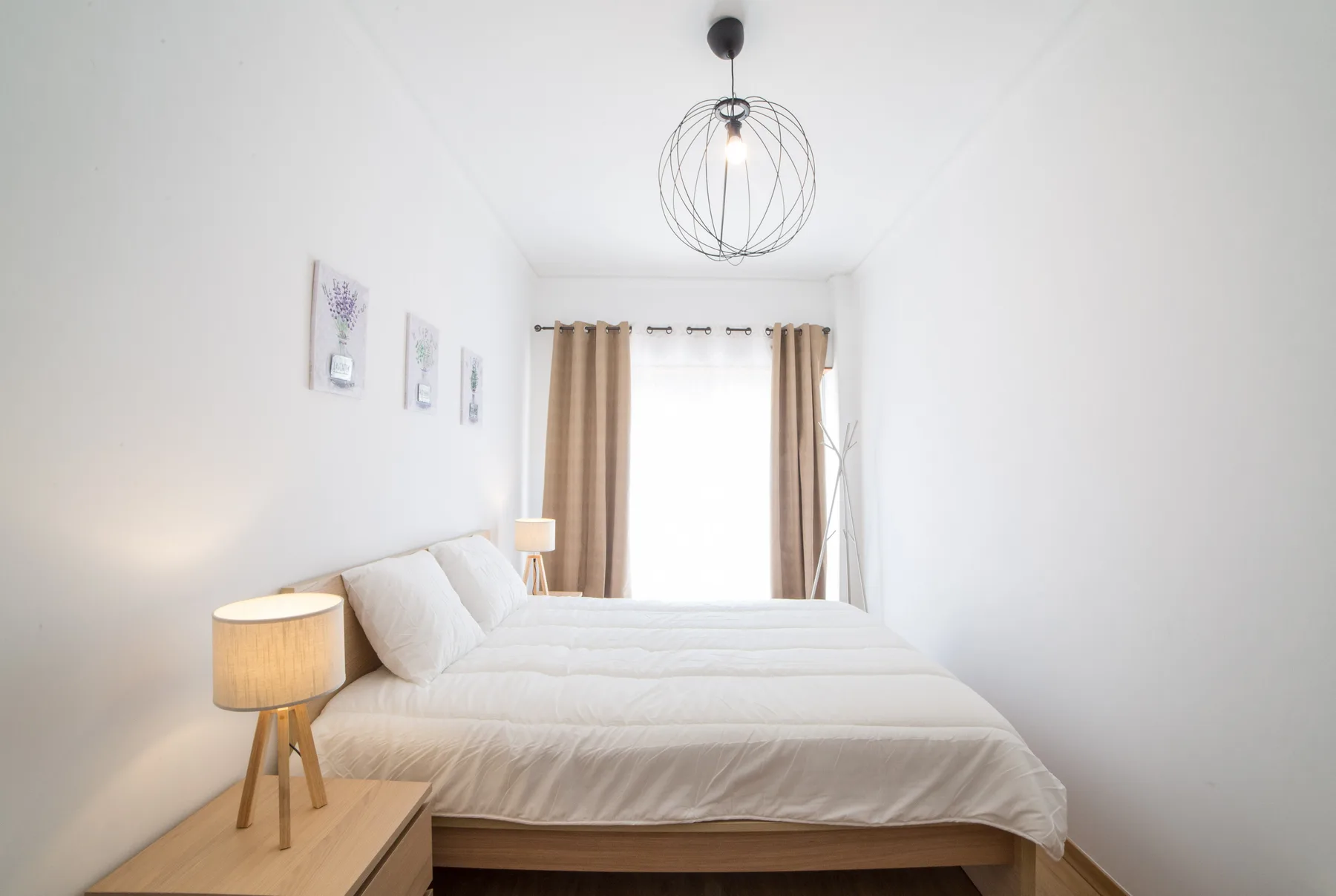 Un dormitorio luminoso con una cama, una mesita de noche y una ventana con cortinas.