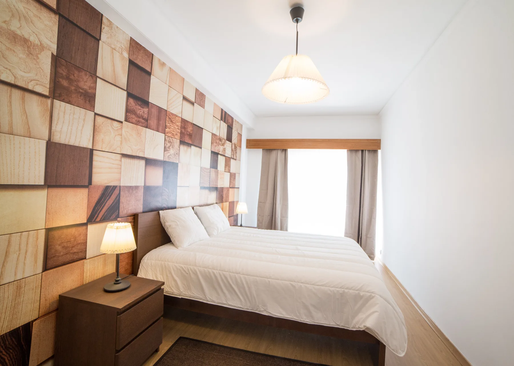 Un dormitorio con una cama, paneles decorativos en la pared y una ventana con cortinas.