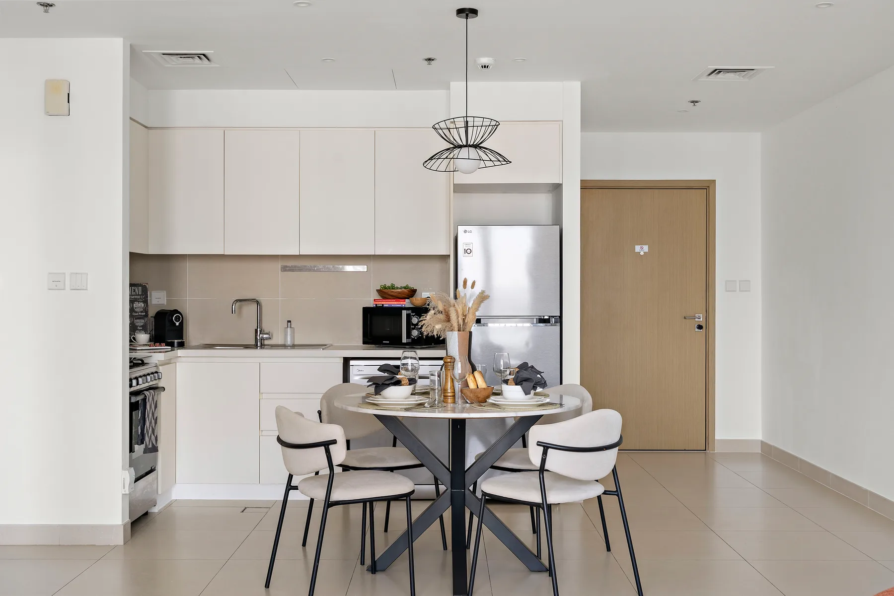 Un comedor luminoso con una mesa redonda junto a una cocina moderna.