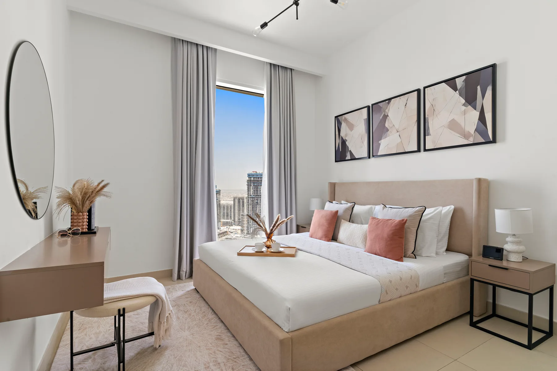 Un dormitorio luminoso tiene una cama bien arreglada junto a una ventana grande.