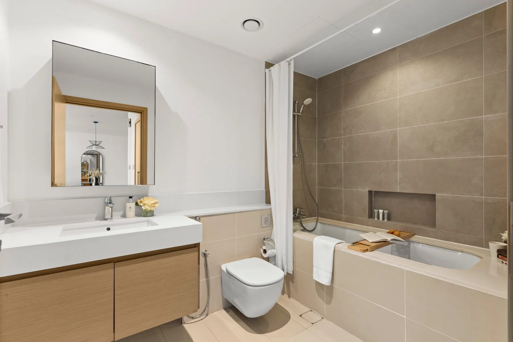 Un baño luminoso con lavabo, inodoro y bañera.
