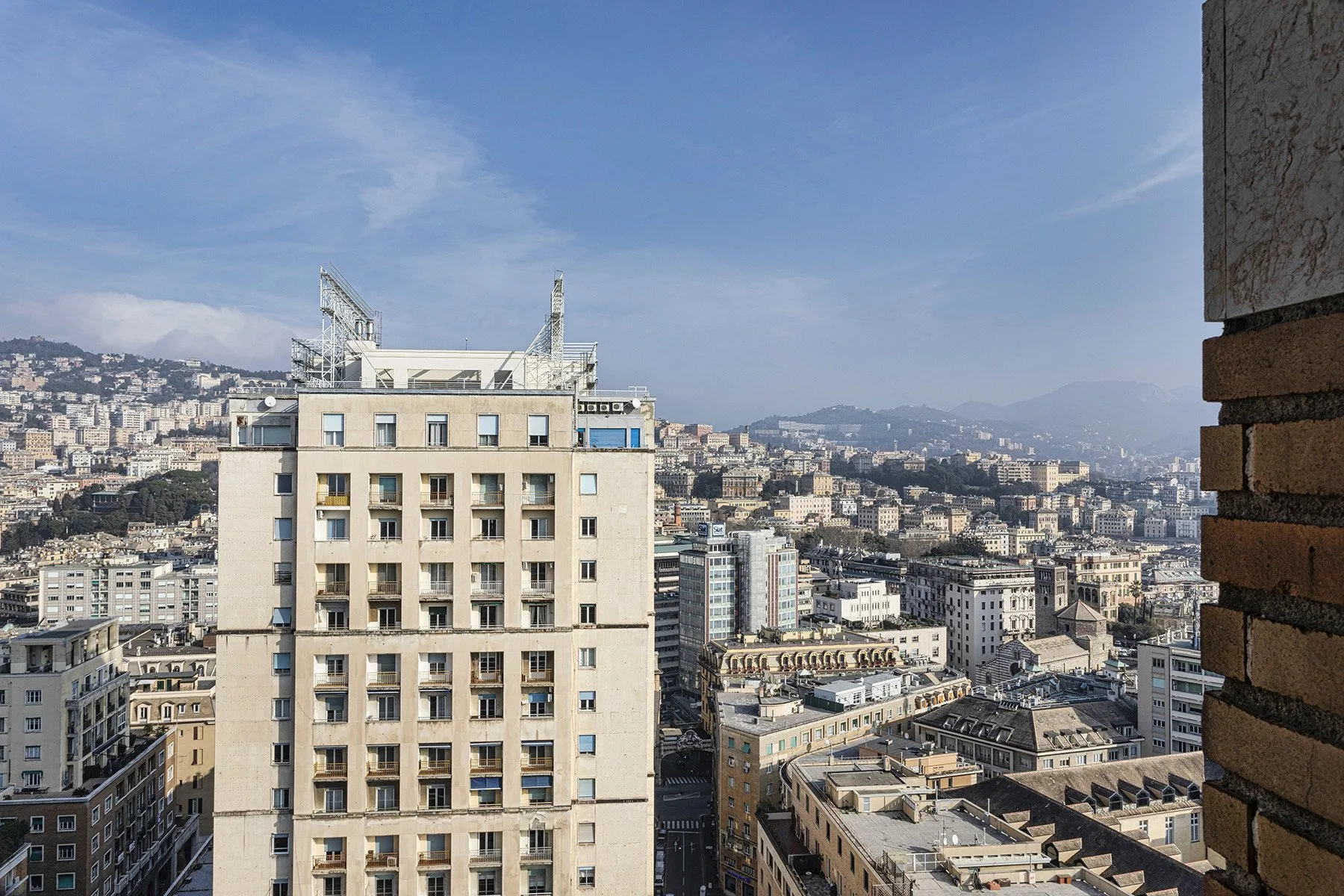 A cityscape of dense buildings beneath a clear blue sky.