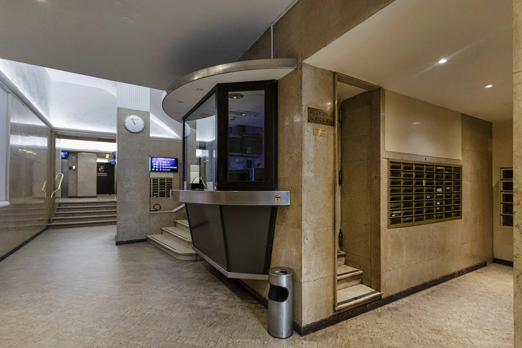 A building lobby with a reception desk and mailboxes along the wall.
