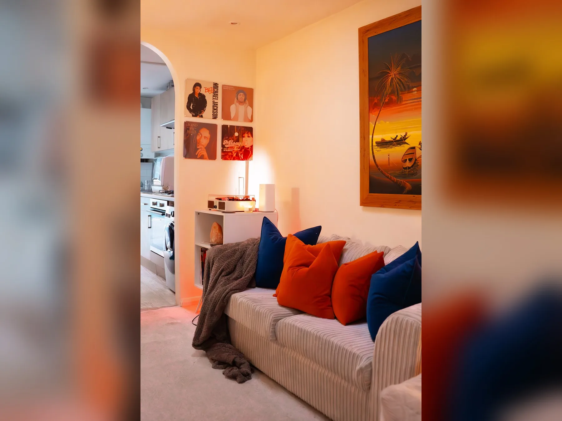 A living room with a striped sofa and colorful cushions.