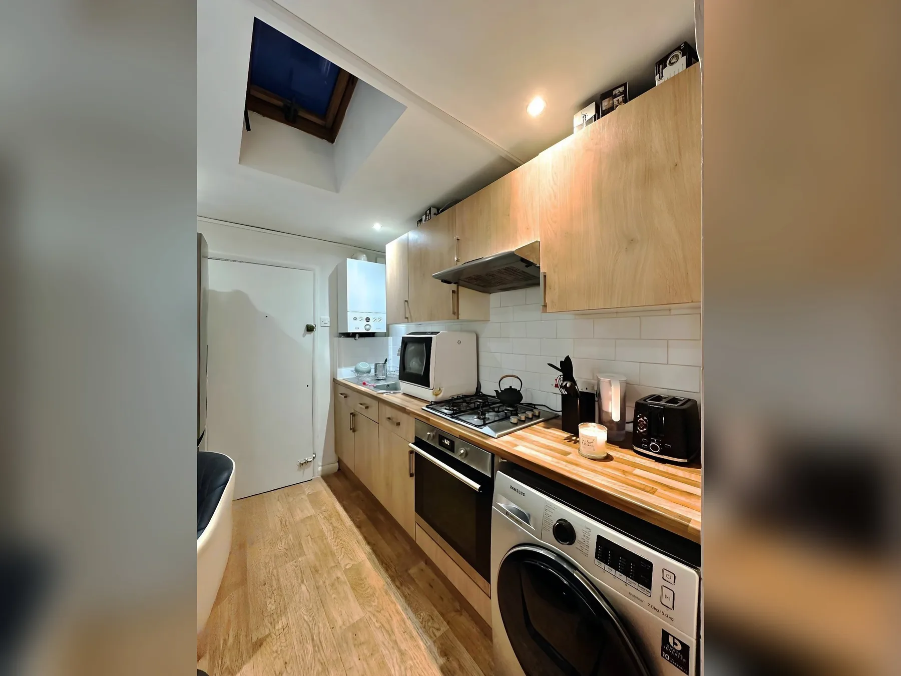 A compact kitchen with wooden cabinets, a countertop, and cooking appliances.