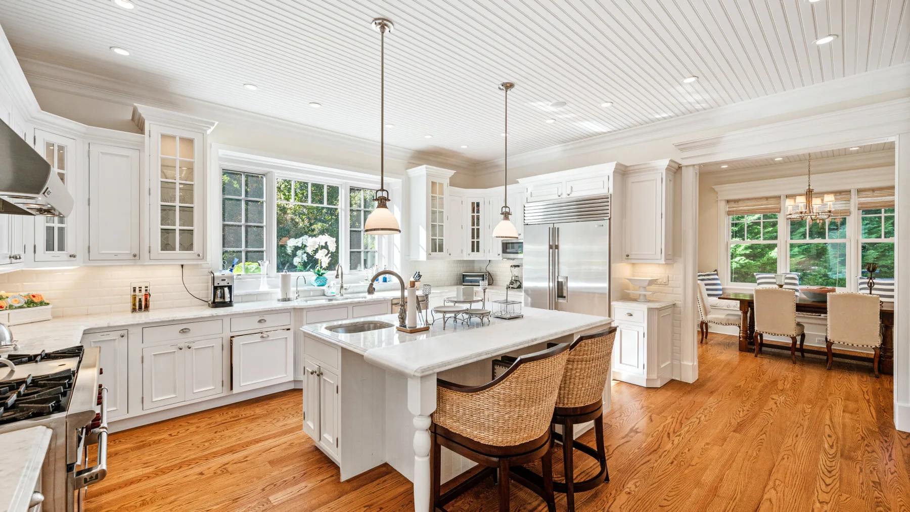 Una cocina luminosa con gabinetes blancos y una isla central.