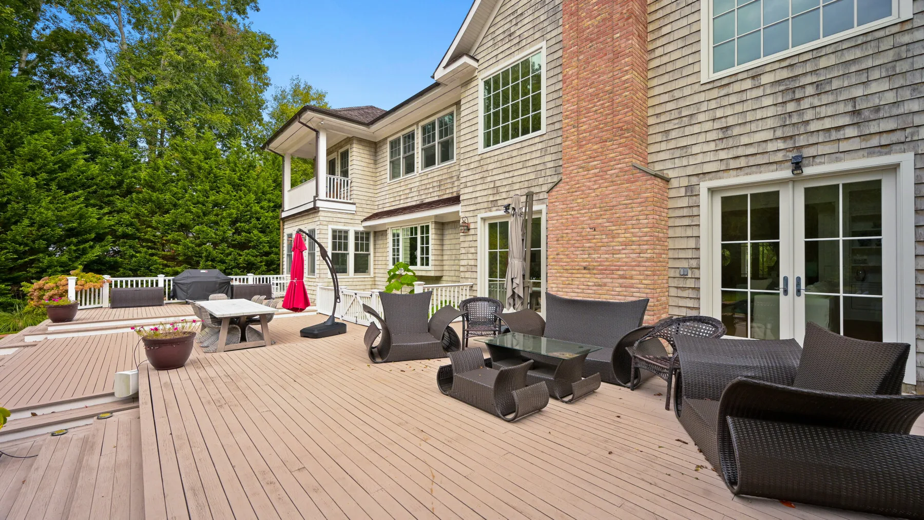 Una amplia terraza exterior con asientos y una mesa junto a la casa.