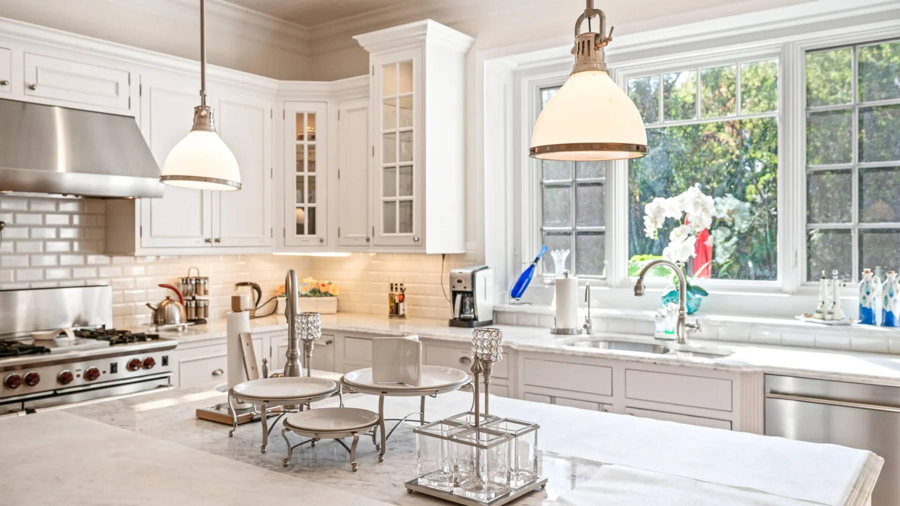 Una cocina luminosa con gabinetes blancos y una isla grande.