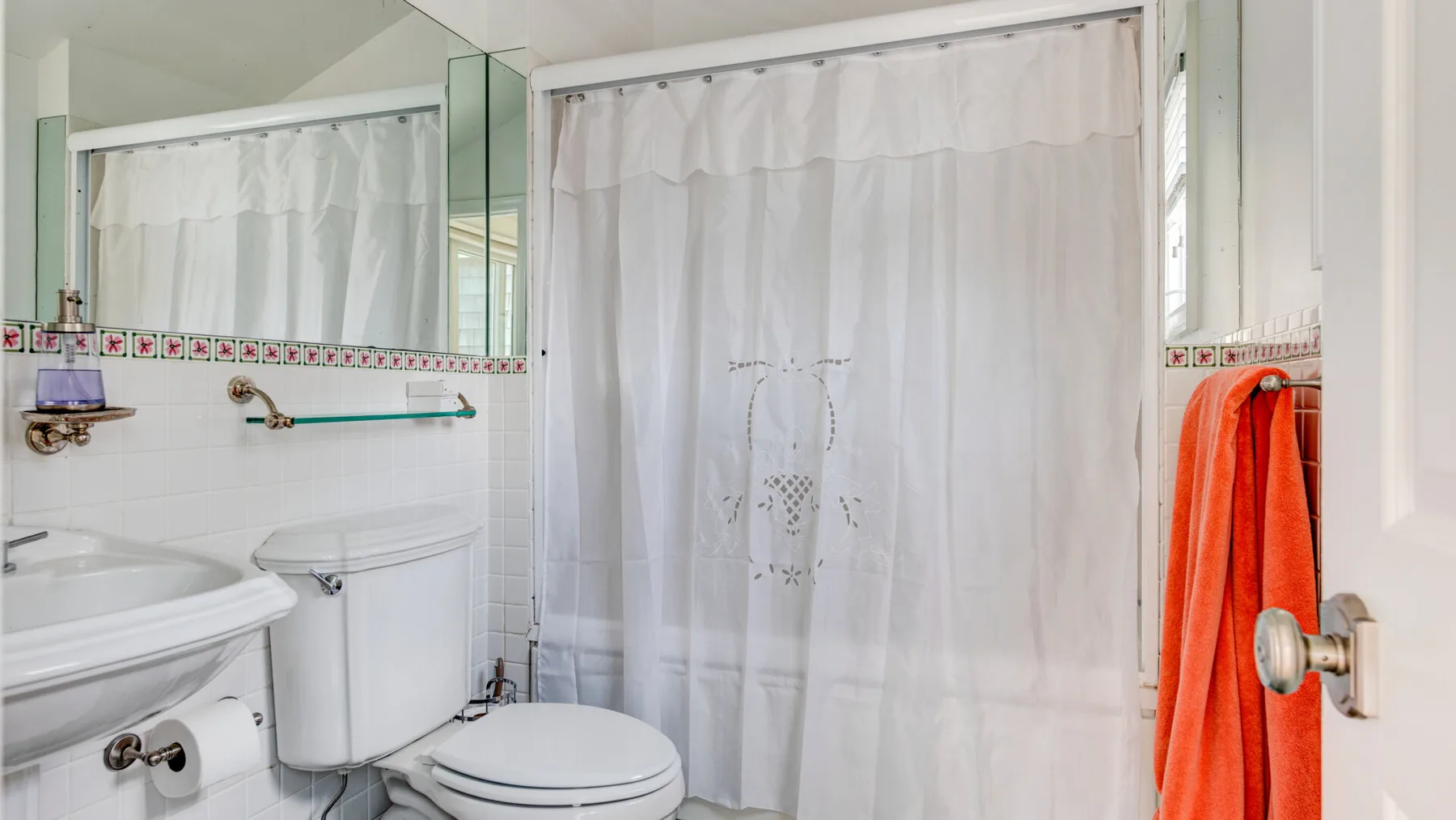 Un baño con lavabo, inodoro y cortina de ducha.