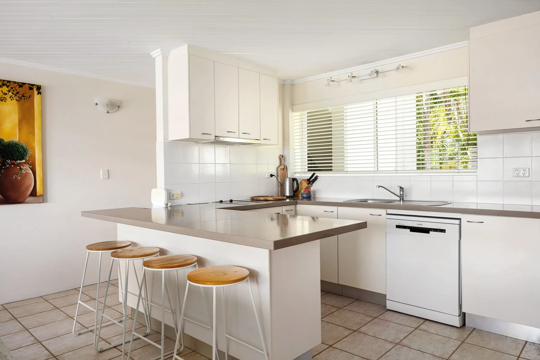 A bright kitchen with a central island and bar seating.