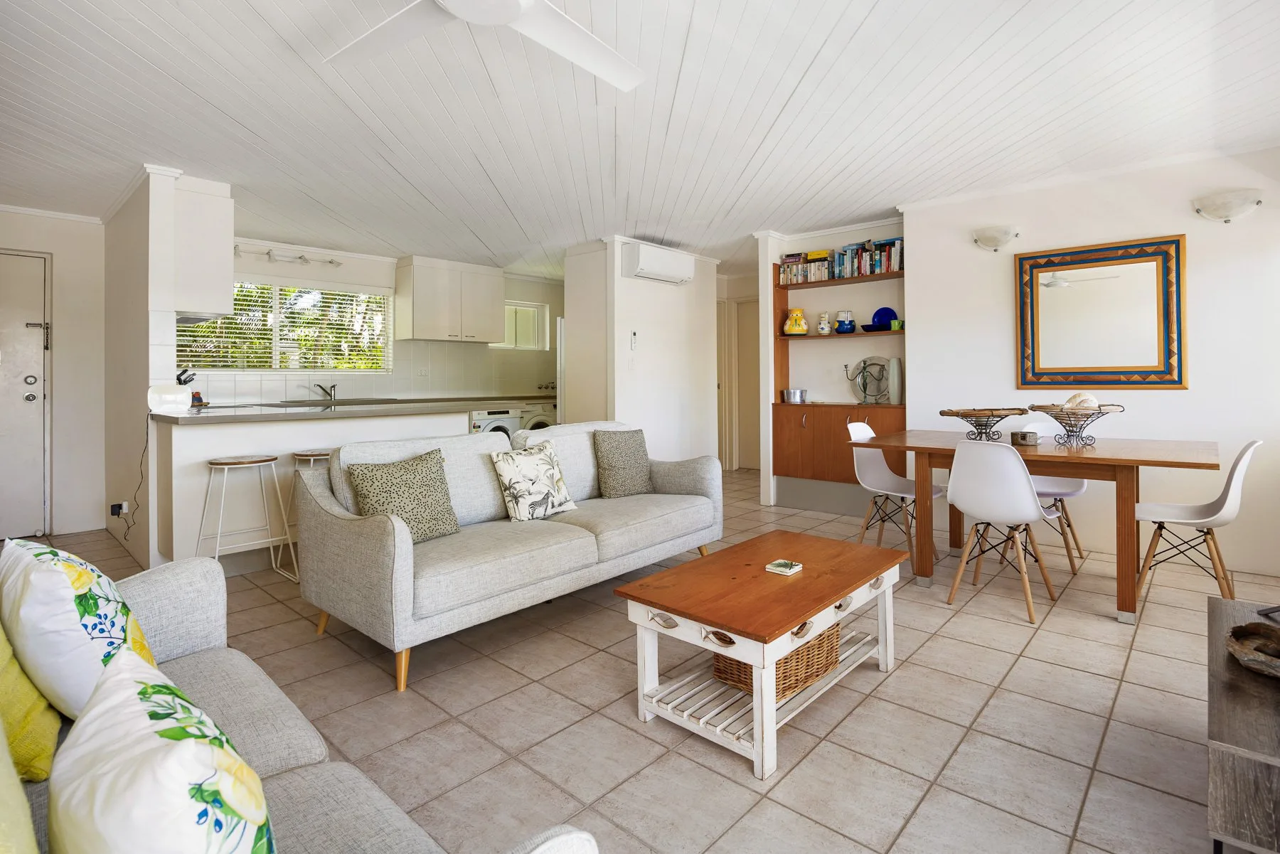 A combined living, dining, and kitchen area with sofas and a dining table.