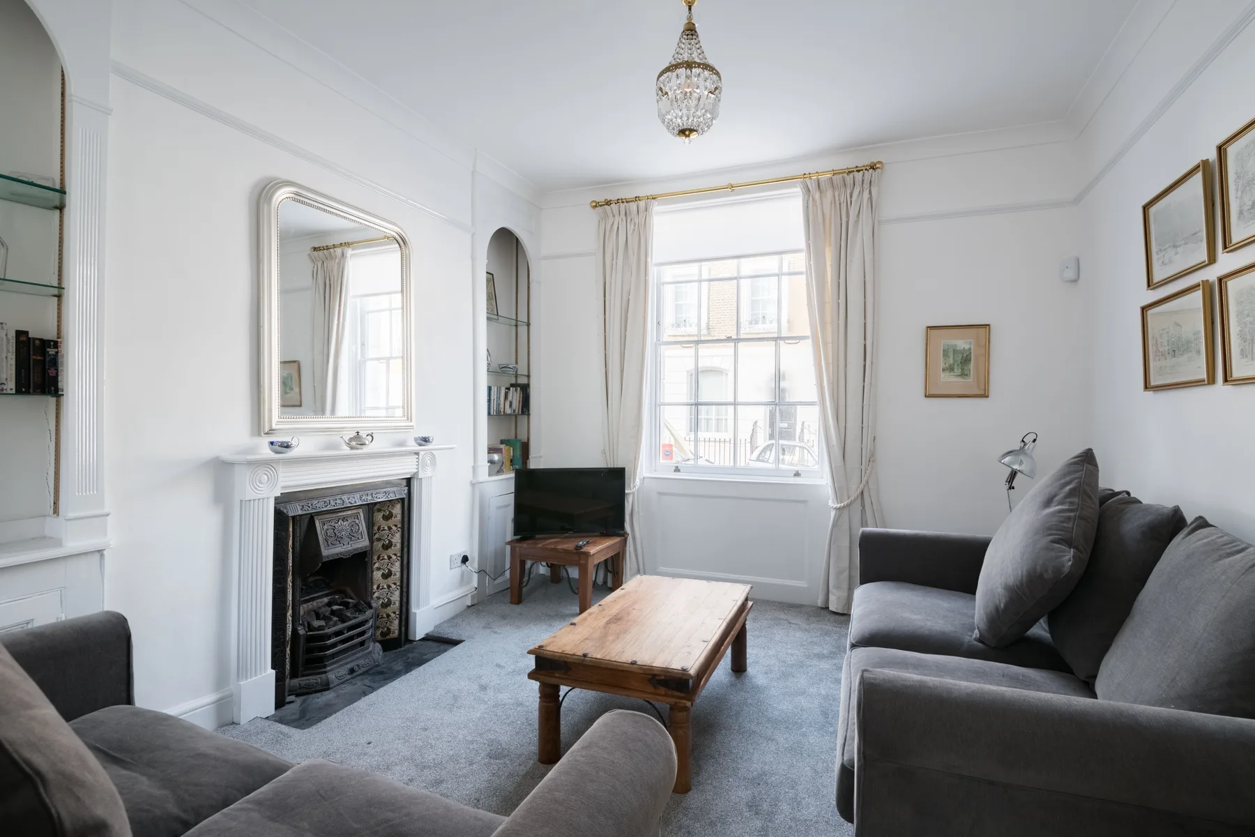 A bright living room with seating, a coffee table, and a fireplace.