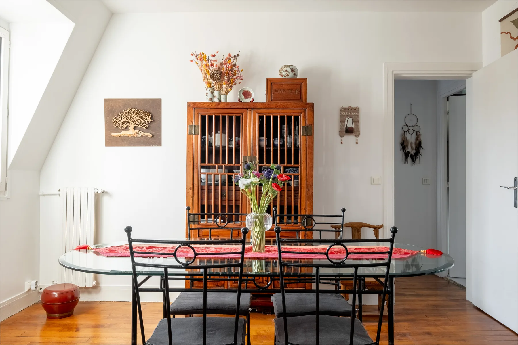 A dining room with a glass table and black metal seating.