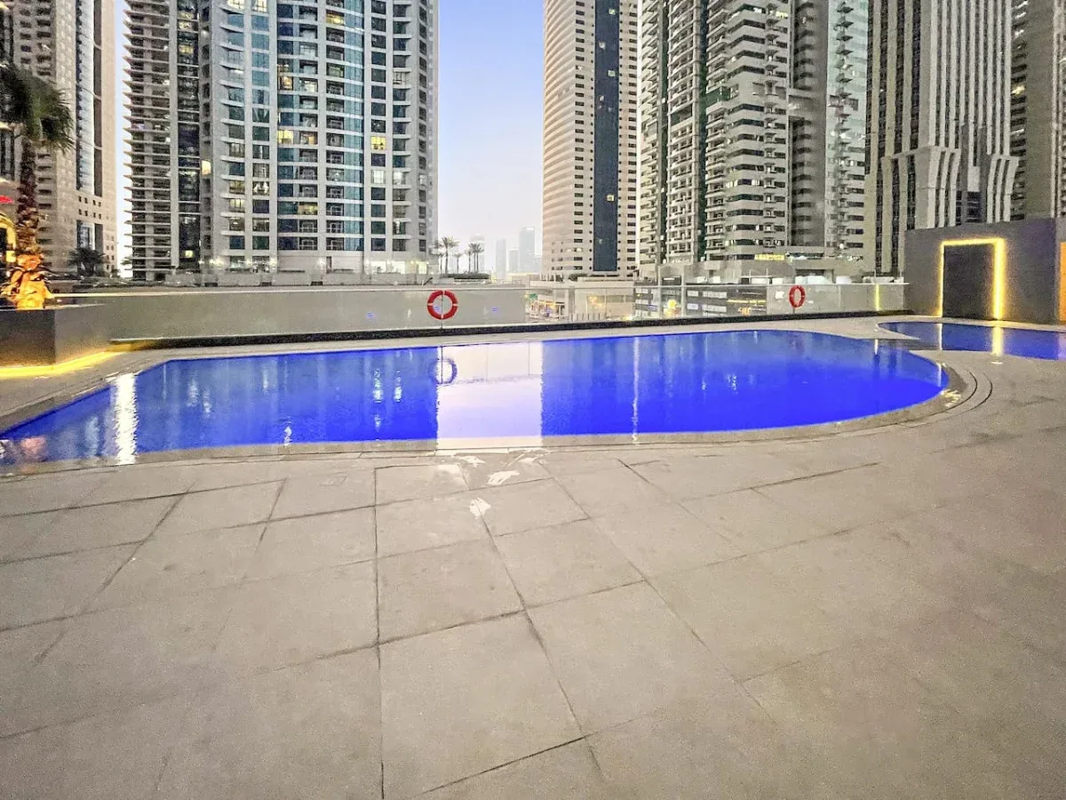 Una piscina al aire libre está rodeada de edificios altos de apartamentos.