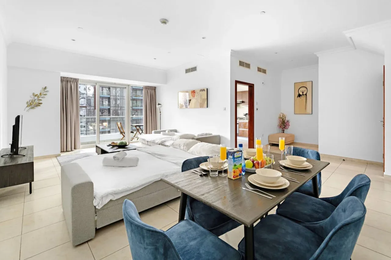 Una luminosa sala-comedor diáfana con la mesa puesta y ventanales.