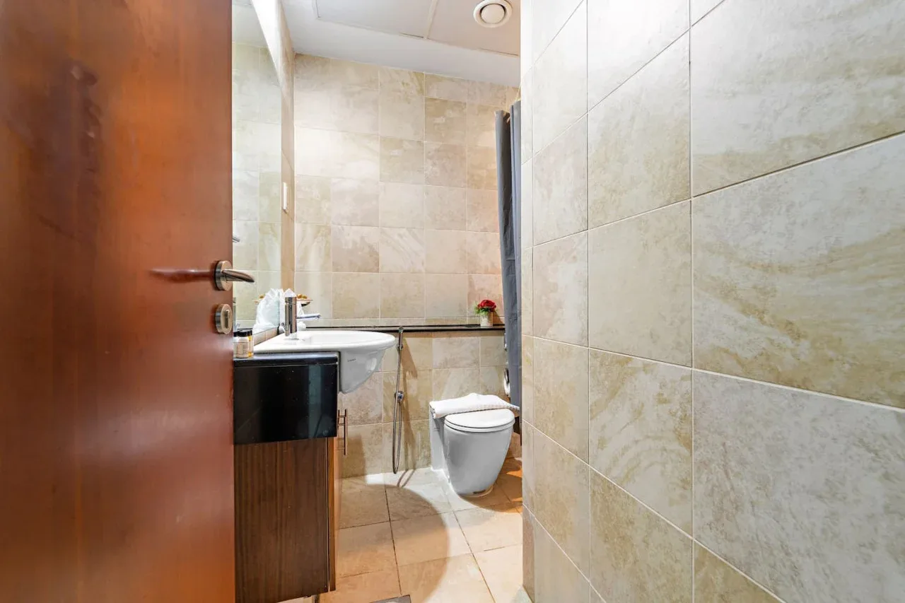 Un baño con azulejos, lavabo e inodoro.