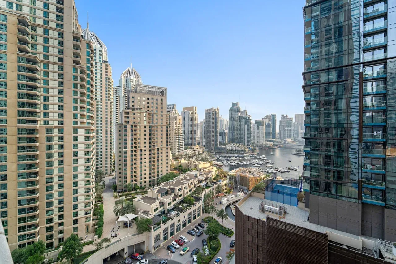 El horizonte urbano se alza sobre una marina y edificios junto al agua.