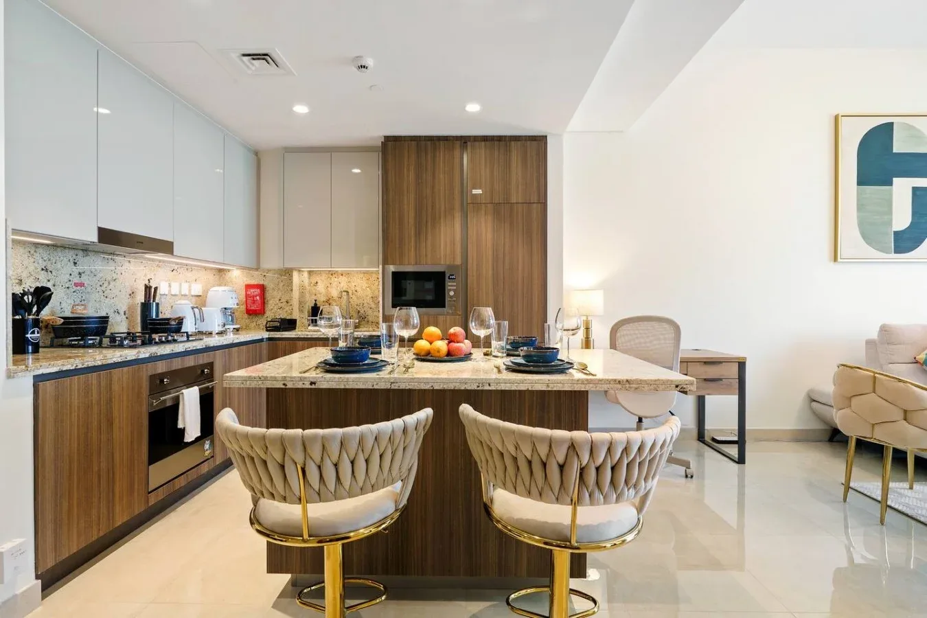 Una cocina moderna con zona de comedor, una isla y dos sillas.