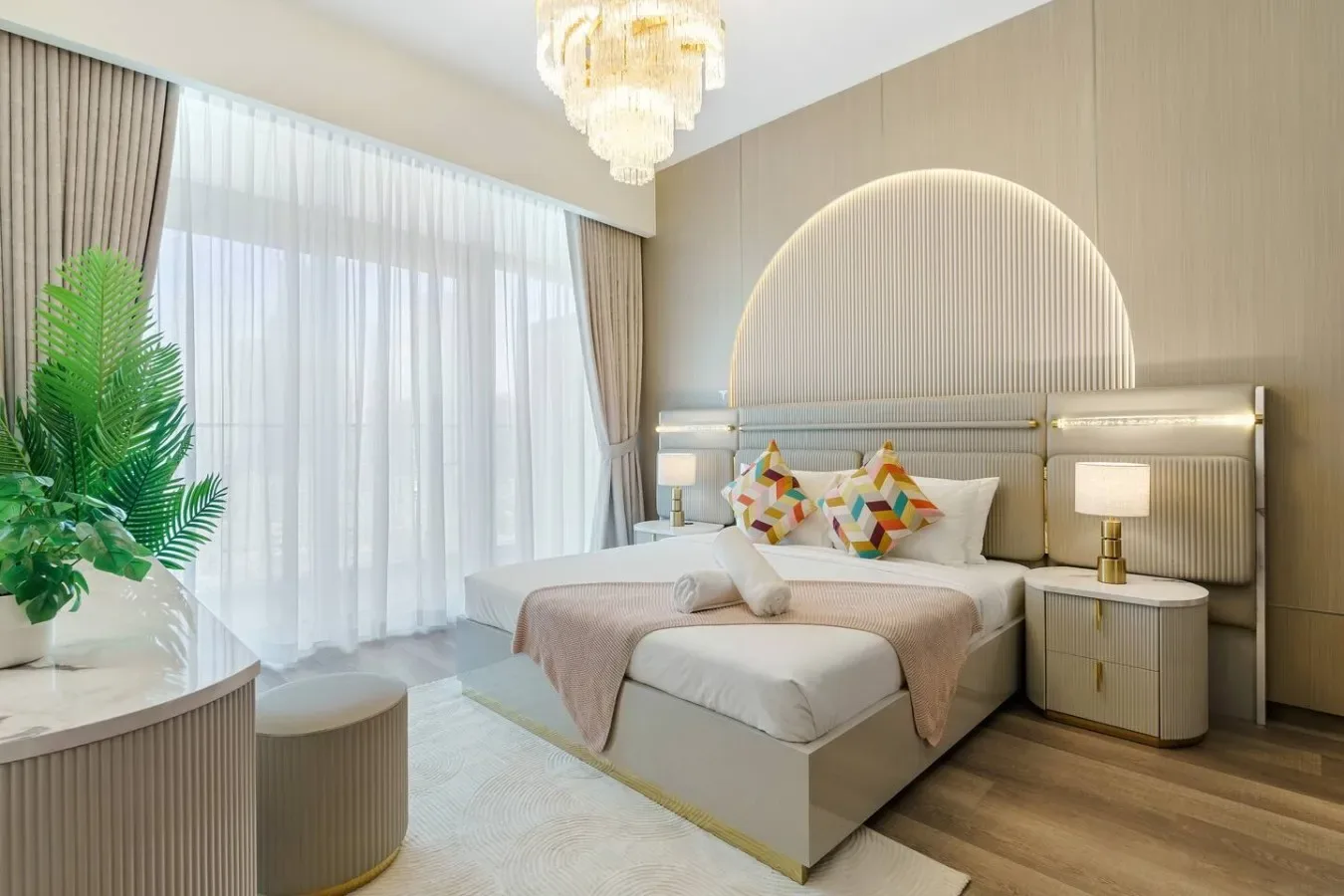 Un dormitorio luminoso con una cama grande, mesitas de noche y cortinas translúcidas.