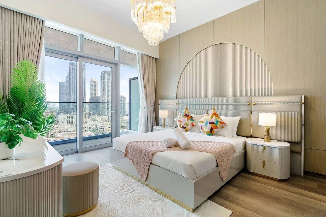 Un dormitorio luminoso con una cama grande, cojines decorativos y ventanales.