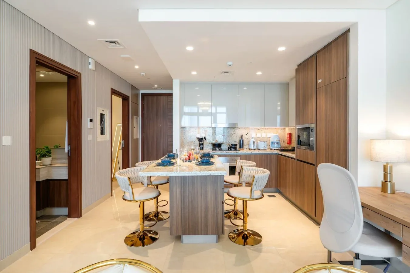 Una cocina moderna con comedor, isla central y asientos altos.